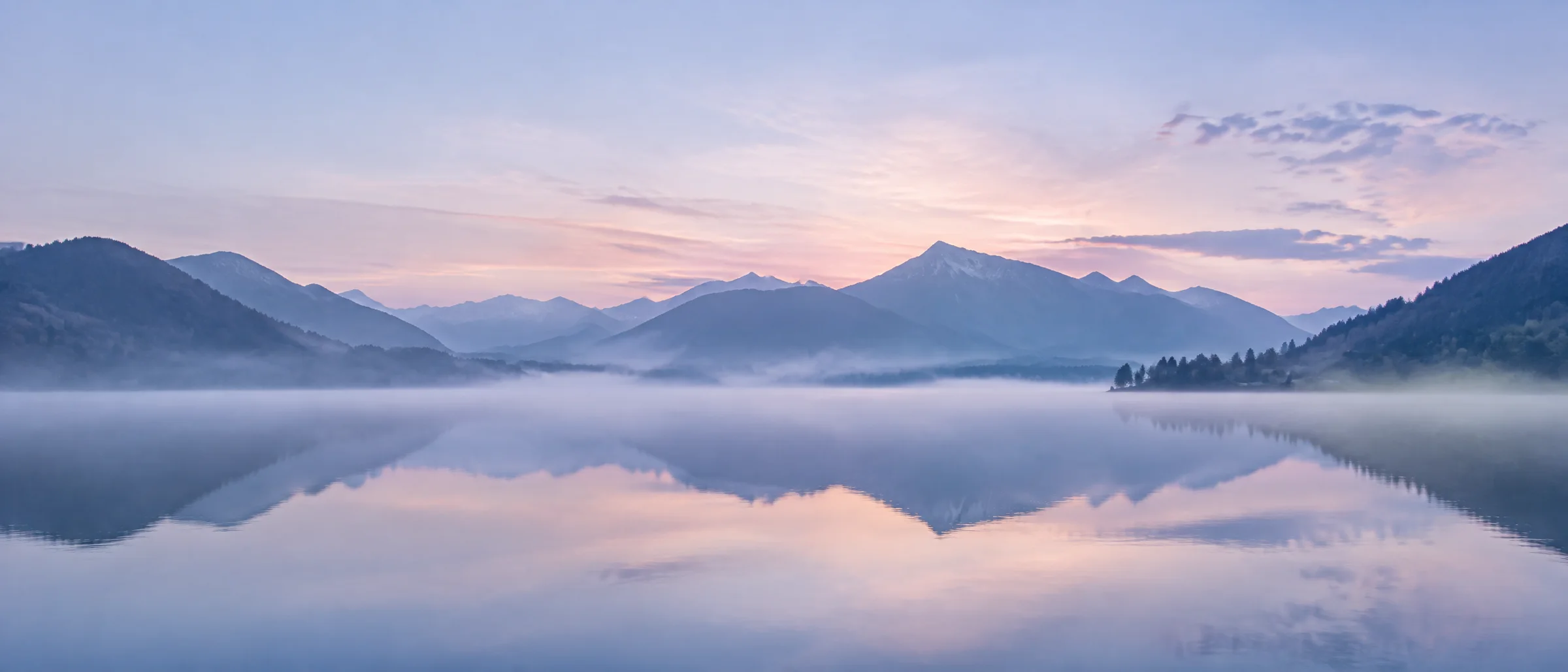 Tegernsee in der Morgendämmerung mit Nebel über dem Wasser